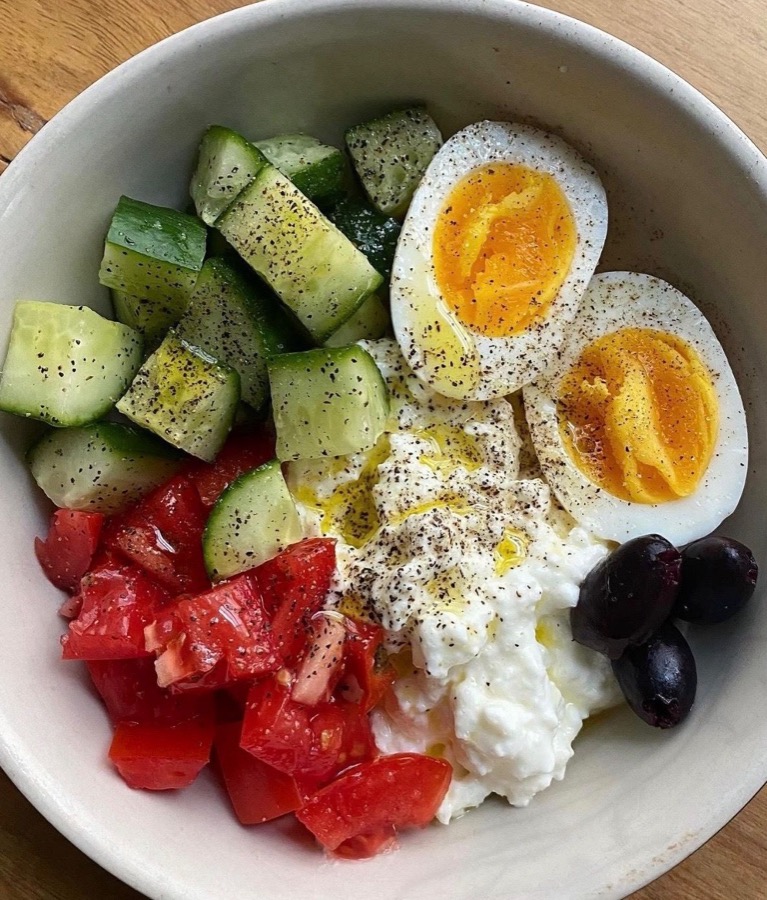 A cottage cheese bowl with cucumber, tomato and egg